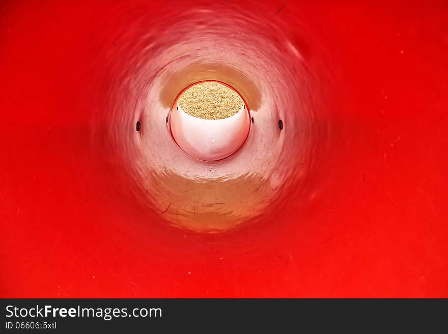 The view inside a red, round, plastic slide. The view inside a red, round, plastic slide