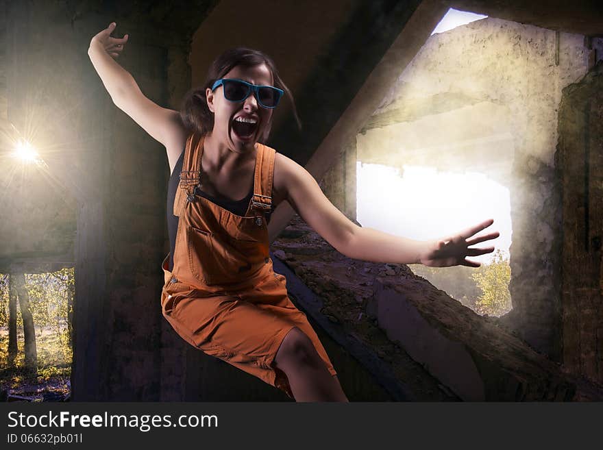 Unique person,young girl dressed in orange overalls in the ruins of an old building. Unique person,young girl dressed in orange overalls in the ruins of an old building.