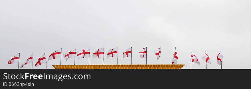 A Line of English Flags on a Building Rooftop. A Line of English Flags on a Building Rooftop.