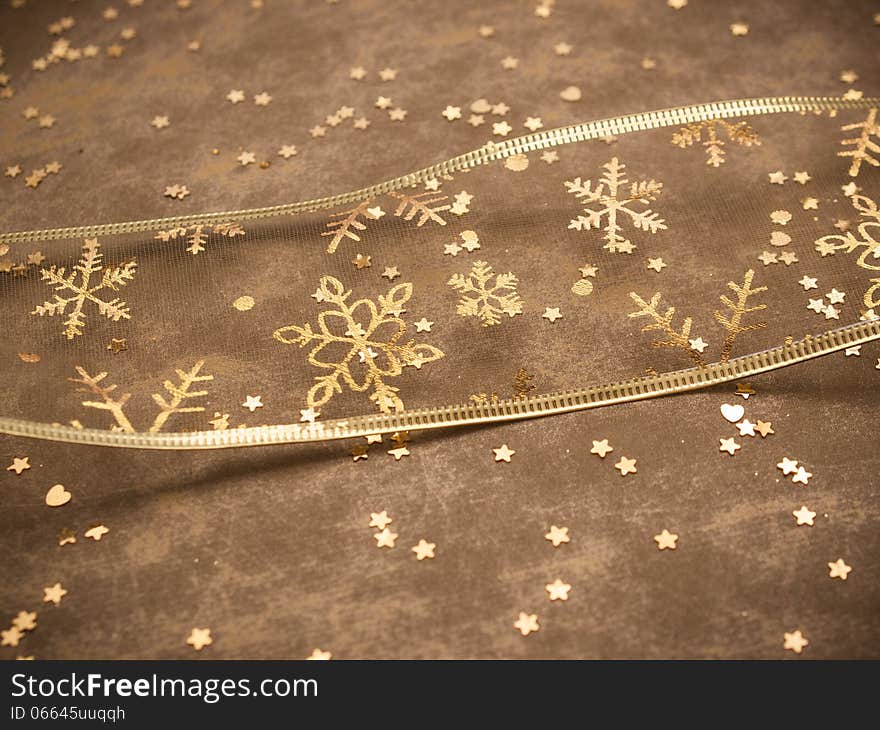 Golden snowflake ribbon with golden stars on golden background. Golden snowflake ribbon with golden stars on golden background