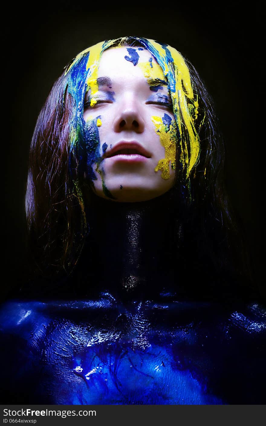 Girl painted blue and yellow on black background