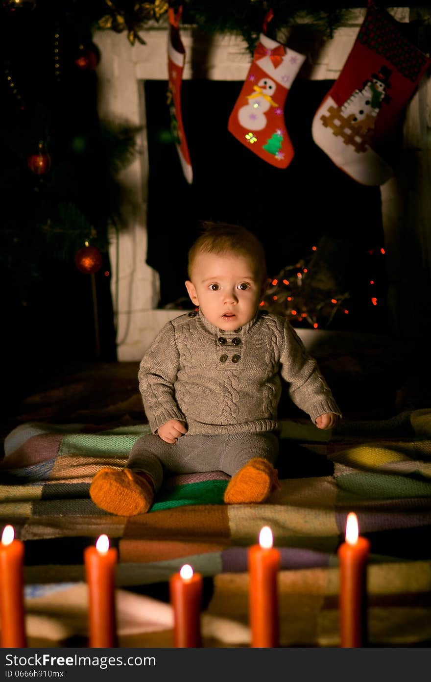 Baby sitting on floor near fireplace on Christmas Eve