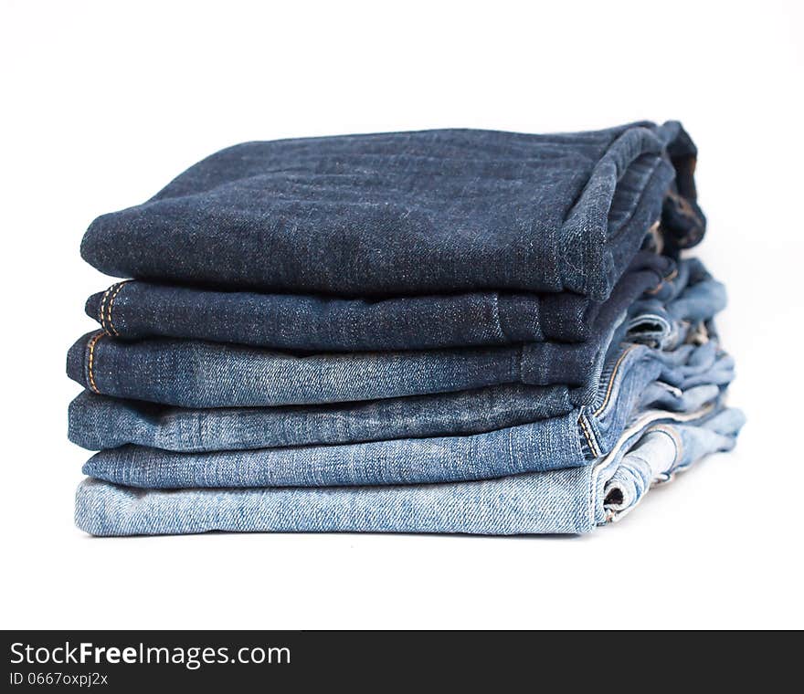 Photo of stack of jeans in gradient color order on white background. Photo of stack of jeans in gradient color order on white background