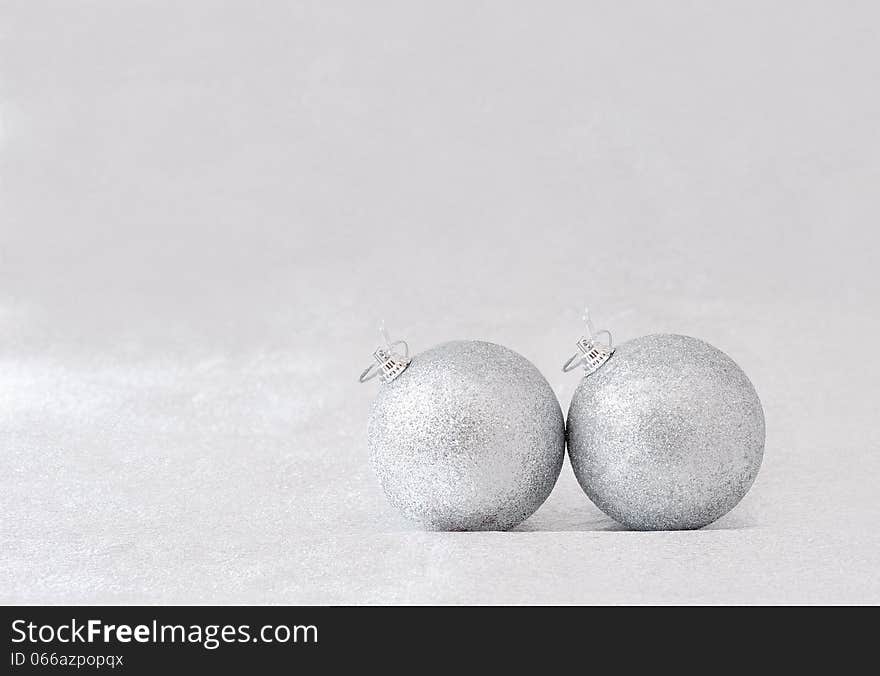 Two silver balls for the Christmas tree on gray background. Two silver balls for the Christmas tree on gray background