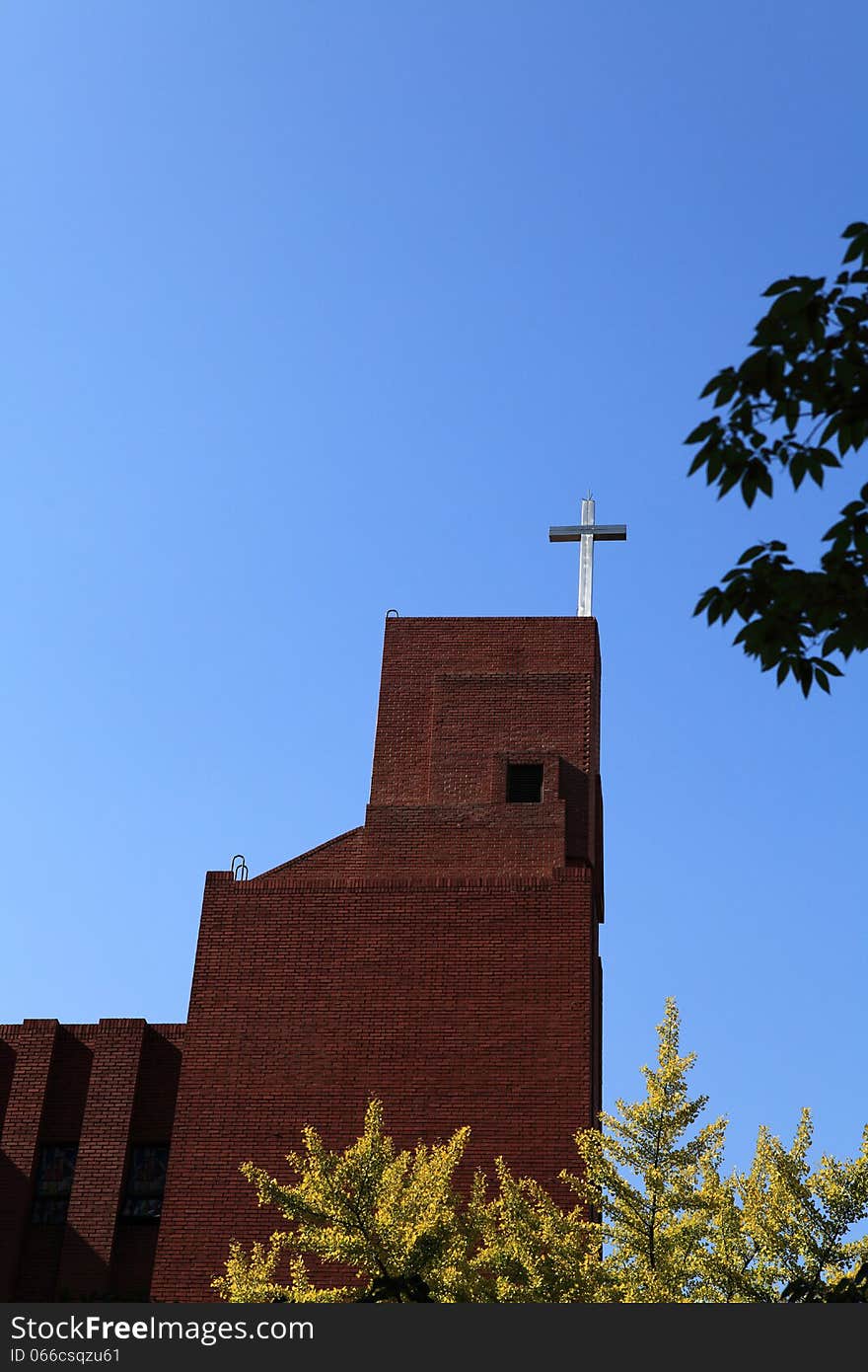 The cross of the church look solemn under the blue sky. The cross of the church look solemn under the blue sky