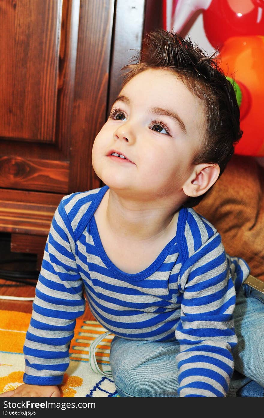 Portrait of a happy baby boy sitting on the floor. Portrait of a happy baby boy sitting on the floor.