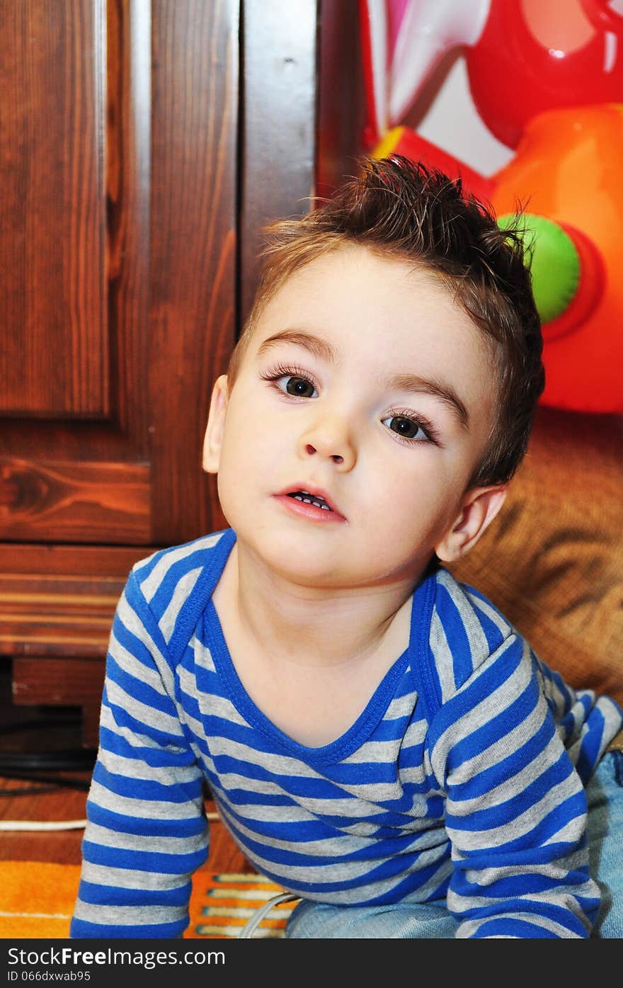 Portrait of a happy baby boy sitting on the floor. Portrait of a happy baby boy sitting on the floor.