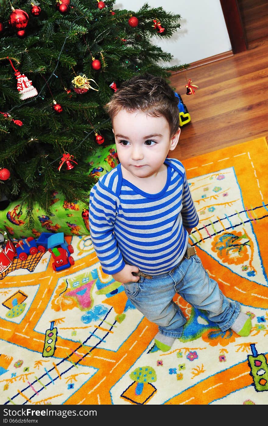 A portrait of a happy baby boy near Christmas tree. A portrait of a happy baby boy near Christmas tree.