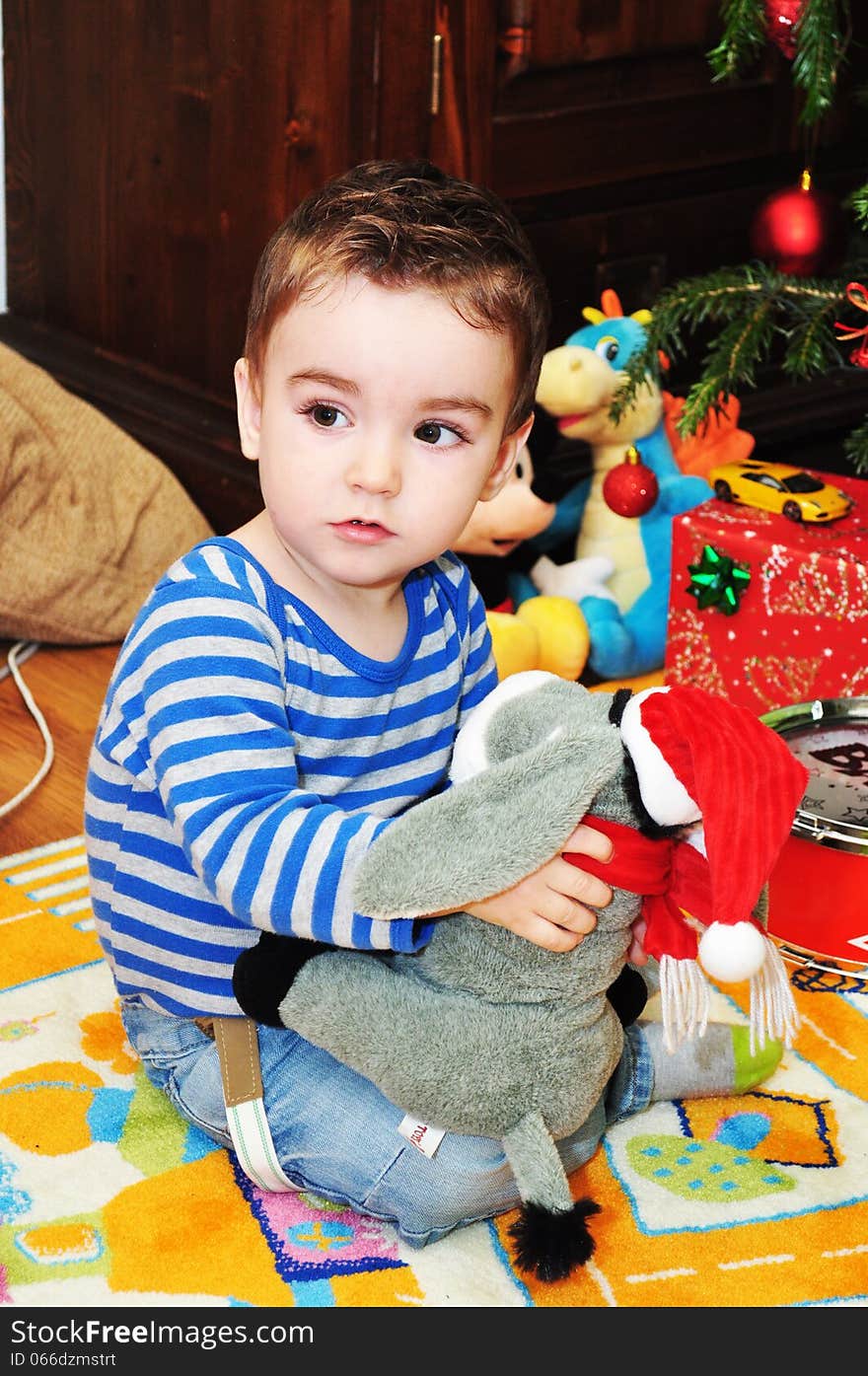 A portrait of a happy baby boy sitting on the floor playing with toys. A portrait of a happy baby boy sitting on the floor playing with toys.