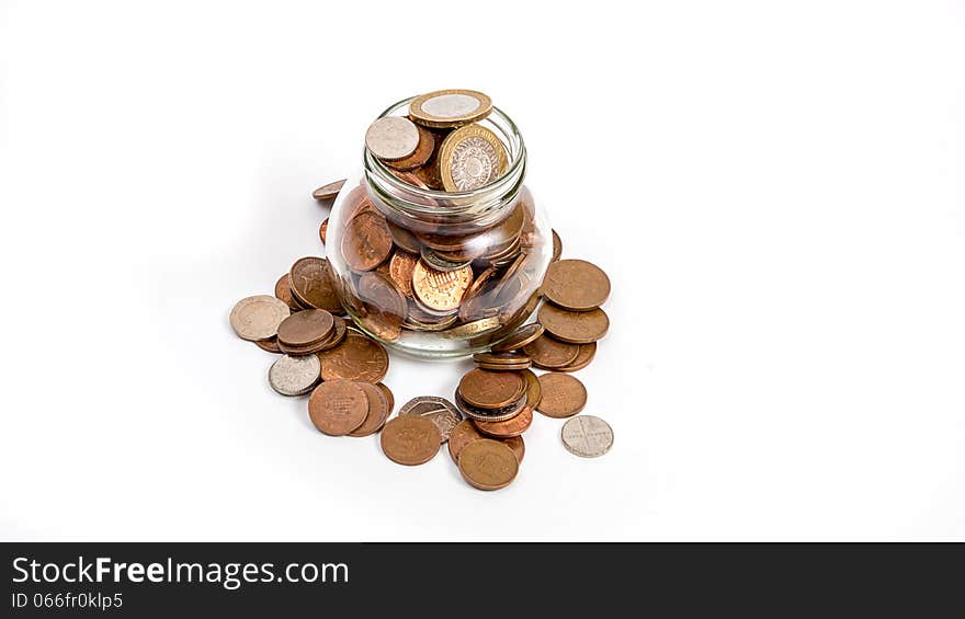 Coins overflowing from money jar isolated on wite background