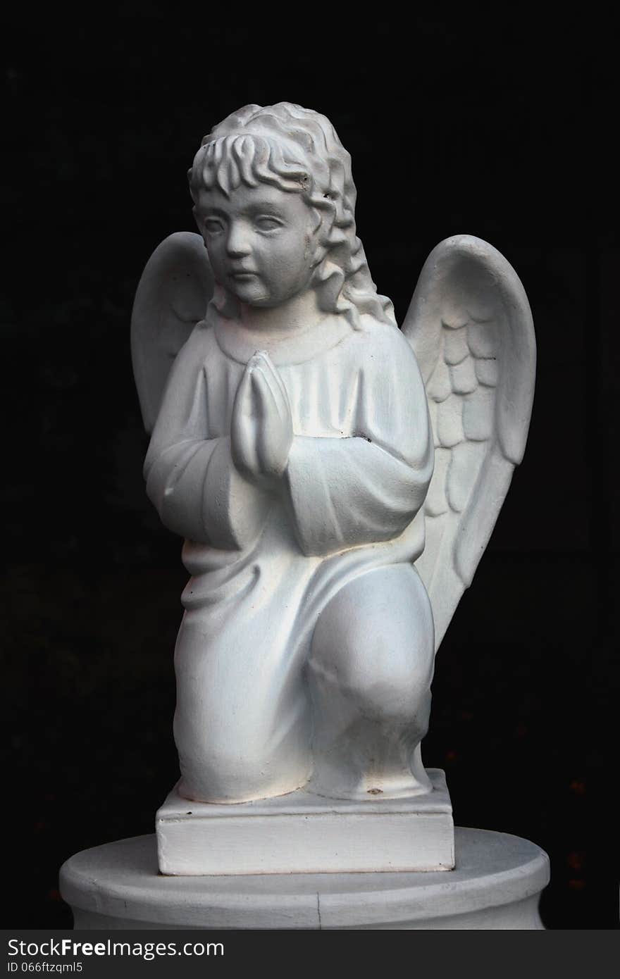 Figure of a praying angel in the cemetery