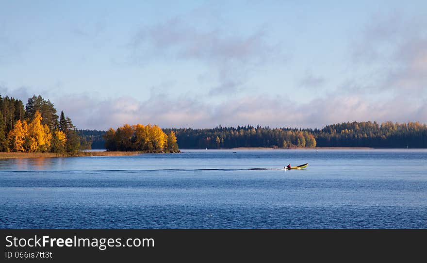 Fisherman on a boat in a lake in autumn