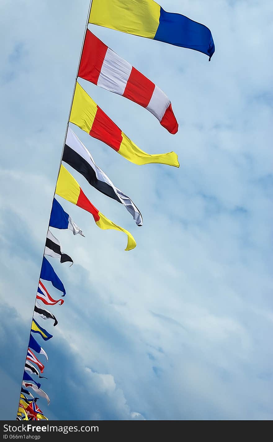 Colorful signal flags in the wind at sky background. Marine colored nautical flags against the sky.