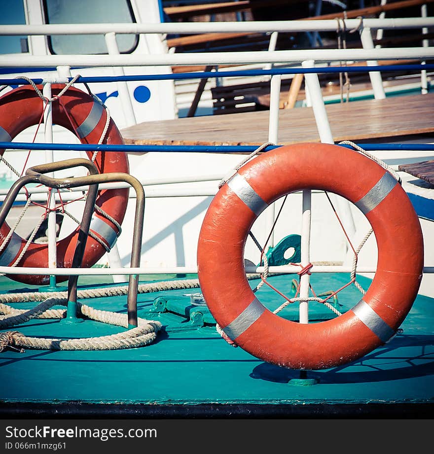 Ship railing and life buoy. View from the deck of a boat. Sea travel background with lifebuoys.