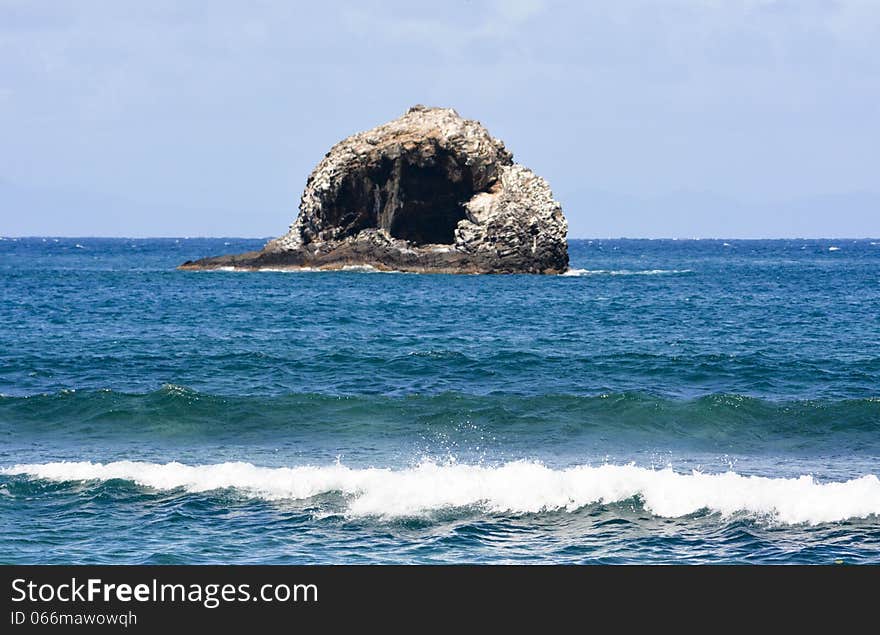 Single island out in the ocean over looking the surf