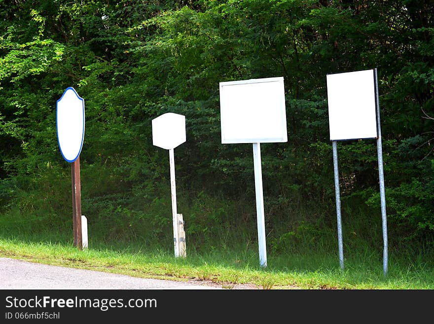 Blank signs at the side of a road right next to each other. Blank signs at the side of a road right next to each other