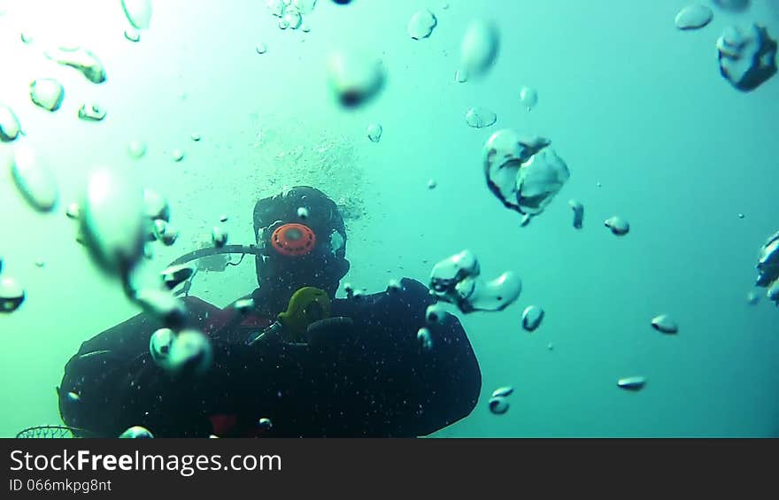 Underwater video. Unrecognized diver rises to the surface. Many air bubbles. Underwater video. Unrecognized diver rises to the surface. Many air bubbles