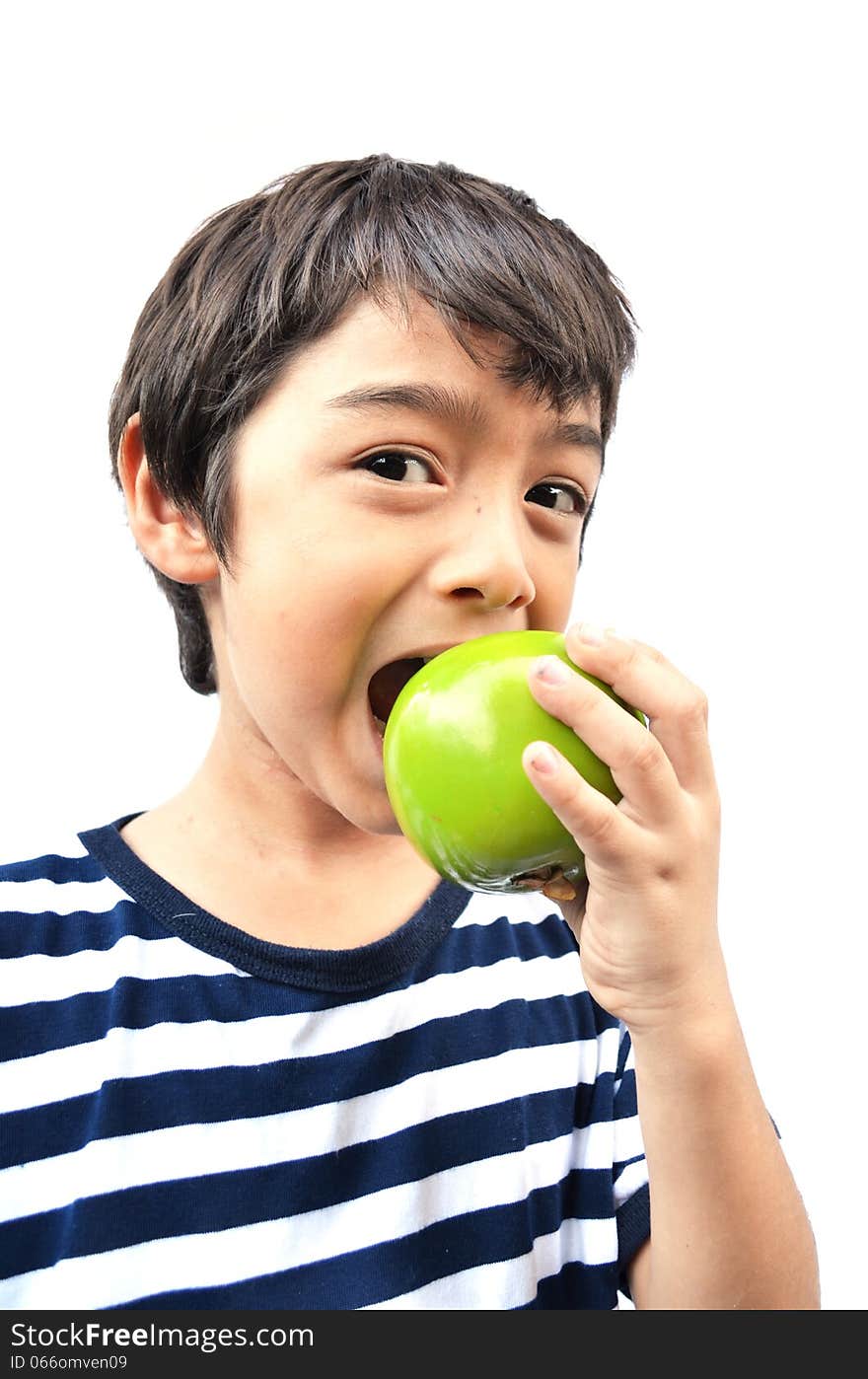 Little boy eating green apple on white background