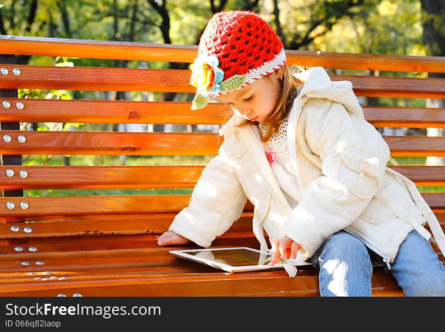 Happy child holding tablet PC in autumn park. Happy child holding tablet PC in autumn park