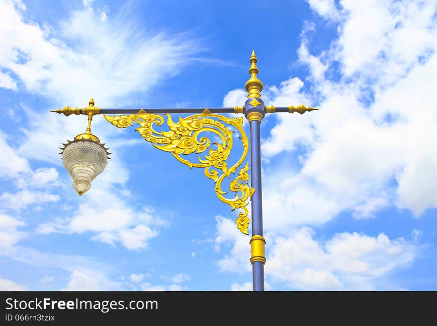 Golden lighting pole on blue sky, Thai style statue