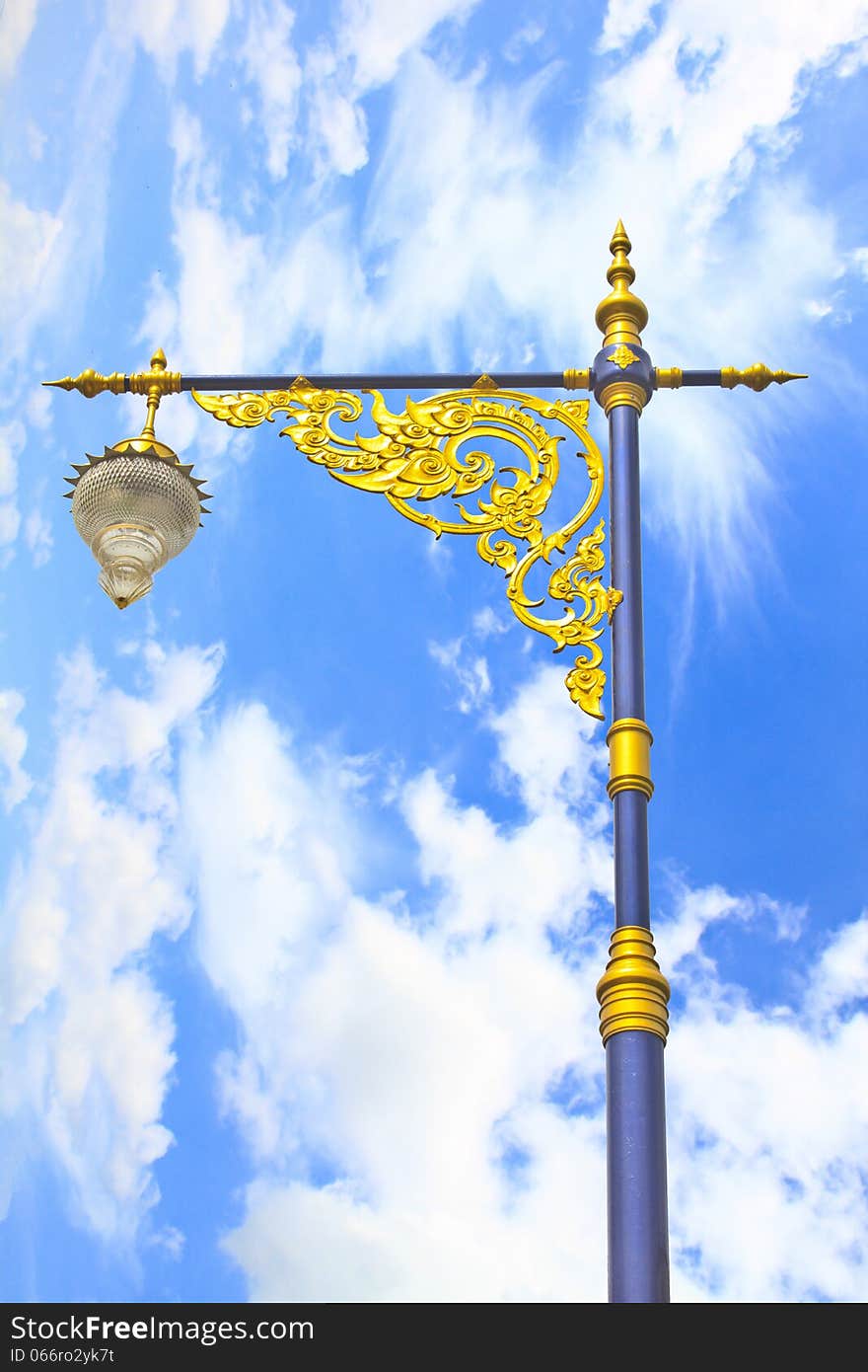 Golden lighting pole on blue sky, Thai style statue