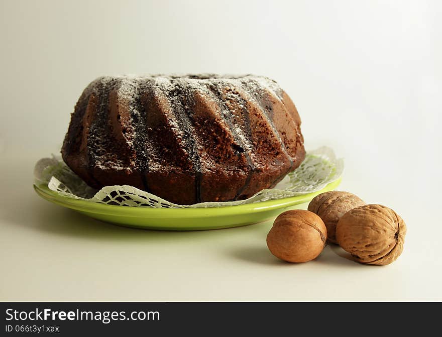 The chocolate cake dusted with icing sugar on a beautiful plate. The chocolate cake dusted with icing sugar on a beautiful plate