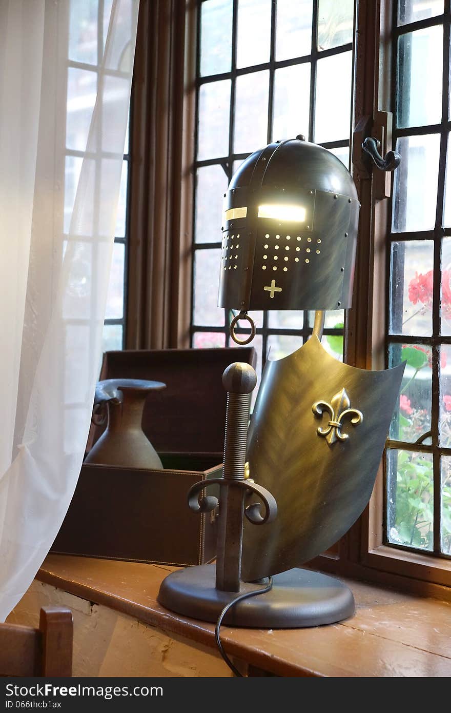 A lamp made from a Knights helmet and shield with a sword sticking out of the base, the eyes illuminated by the inside light. A lamp made from a Knights helmet and shield with a sword sticking out of the base, the eyes illuminated by the inside light