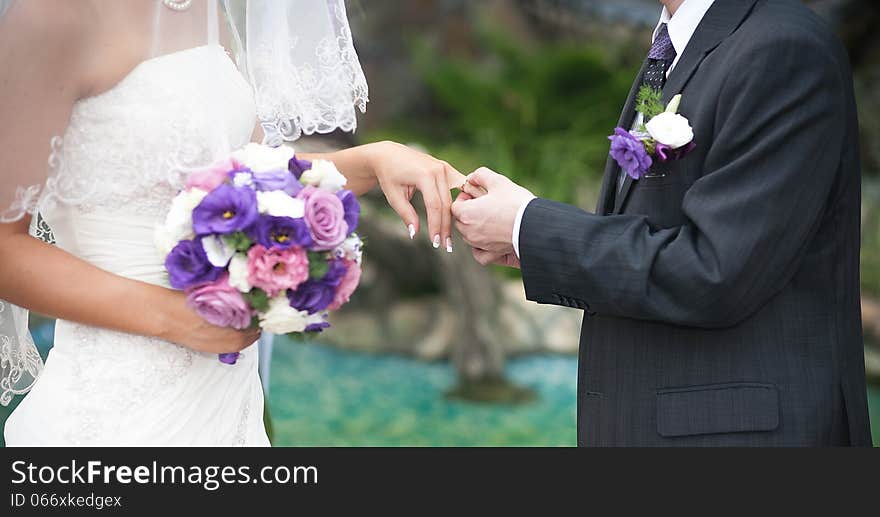 Groom and bride hands on wedding ceremony outdoor