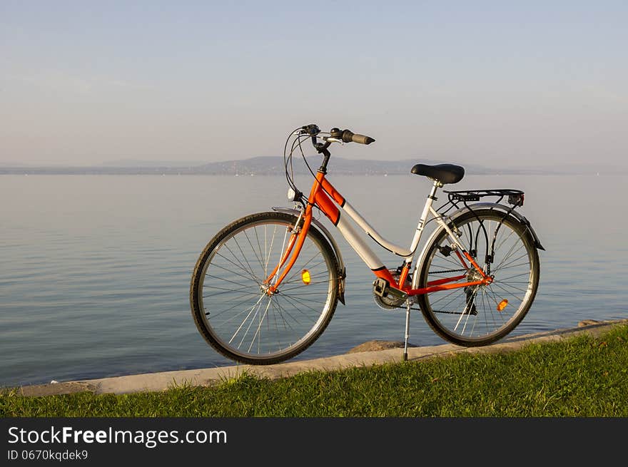 A brand new bicycle parked on the lakeside. A brand new bicycle parked on the lakeside.