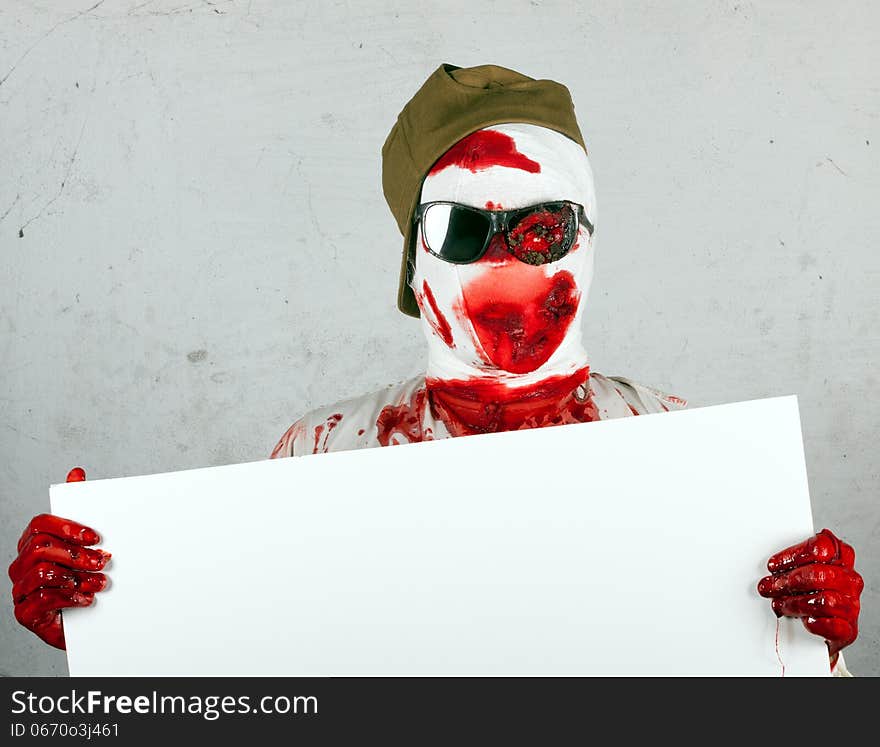 Scary bloody zombie wearing a cap and glasses