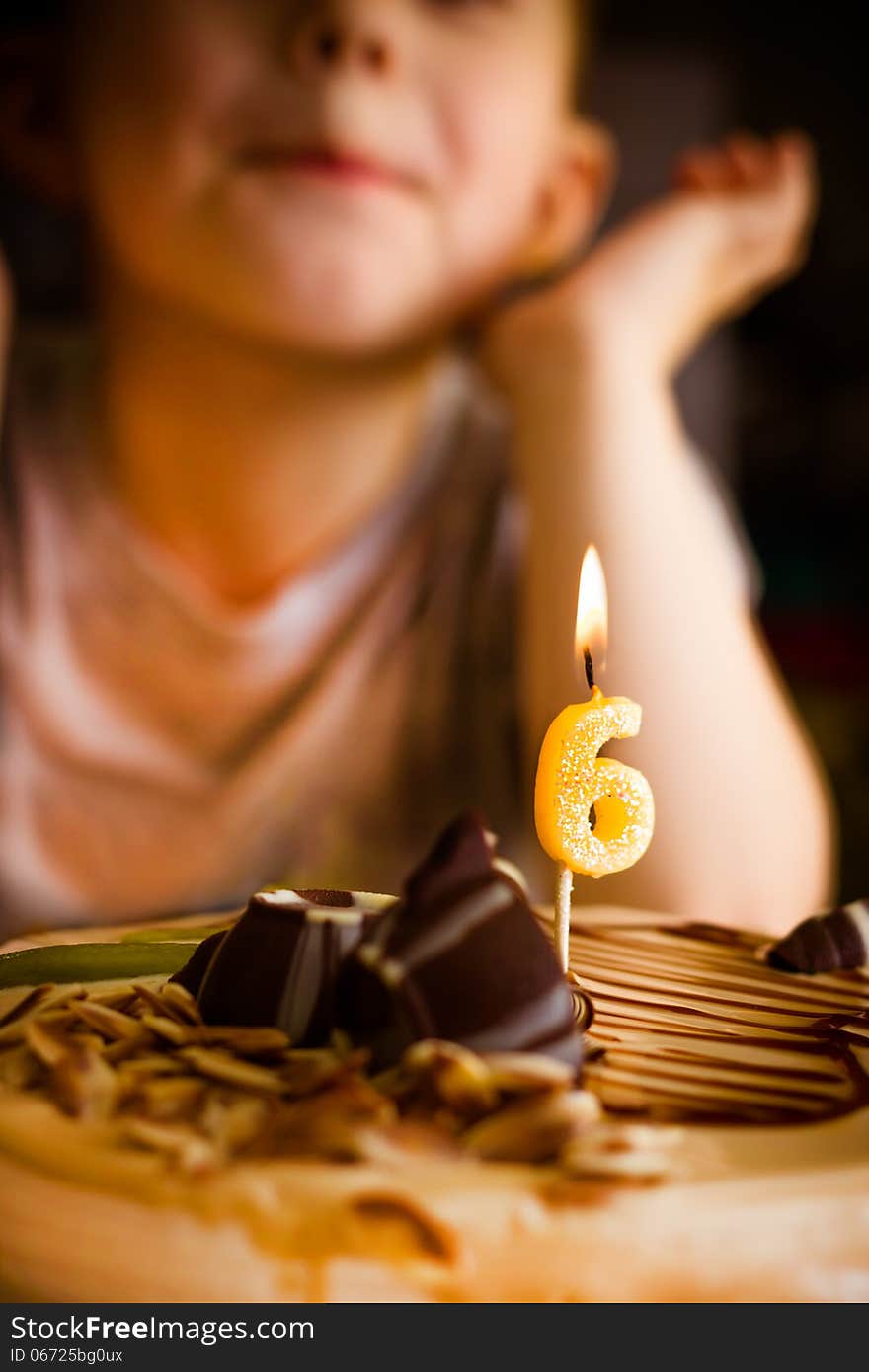 The boy looks at the birthday cake. The boy looks at the birthday cake