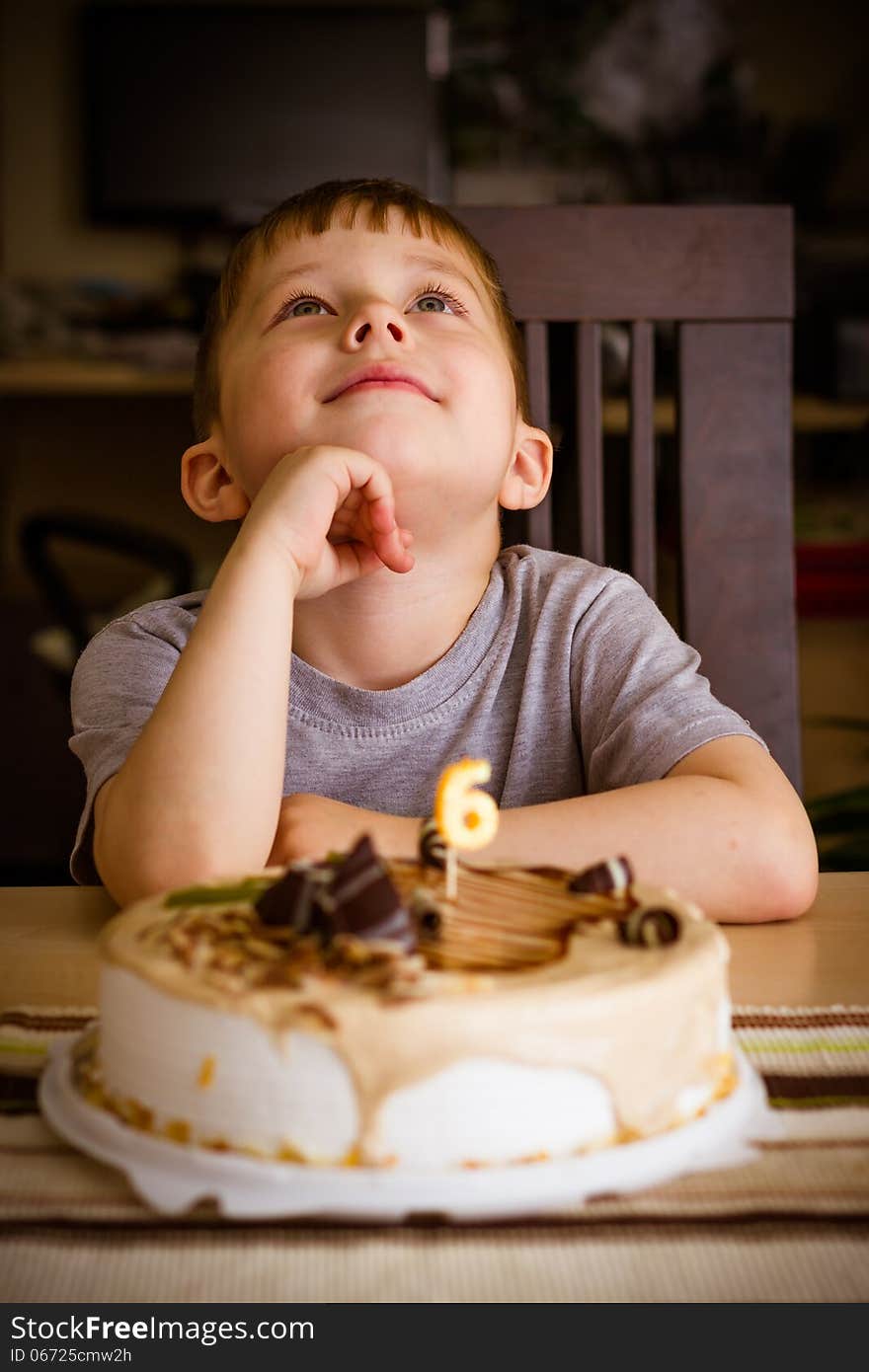 The boy looks at the birthday cake. The boy looks at the birthday cake