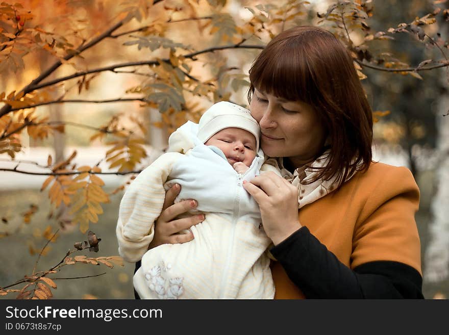 Newborn on the mother hands in the park in autumn. Newborn on the mother hands in the park in autumn