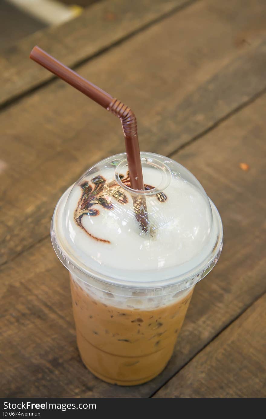 Iced coffee on the wooden table in the garden of coffee shop.