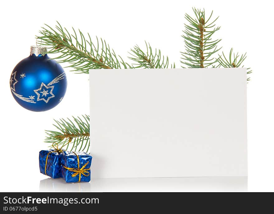 Fir-tree branch with a Christmas toy, souvenirs and a card isolated on white. Fir-tree branch with a Christmas toy, souvenirs and a card isolated on white