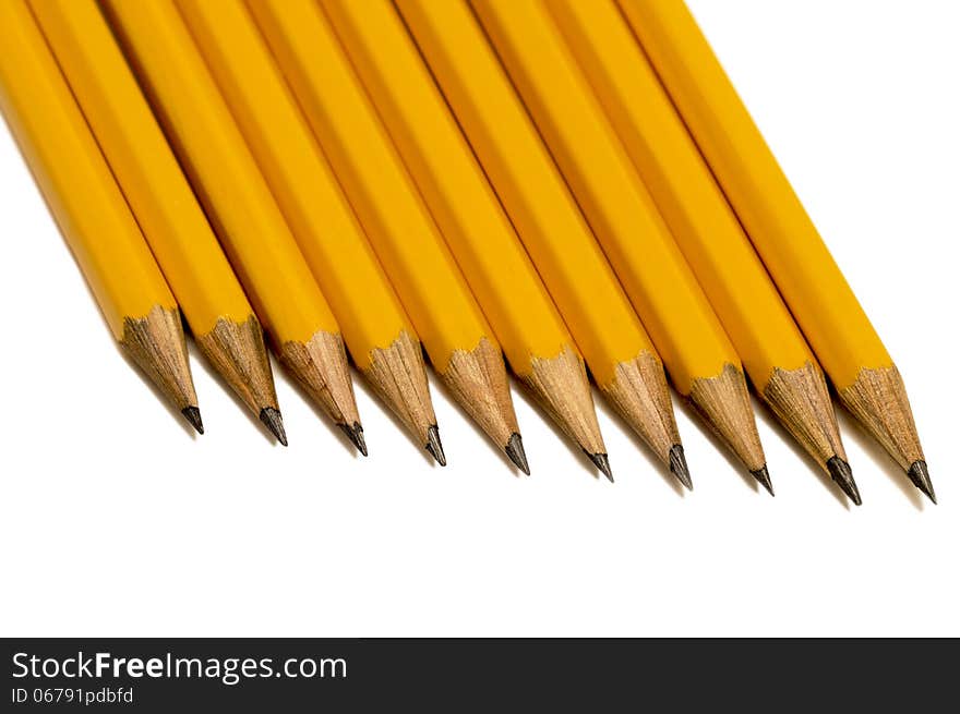 Overhead, close up shot of sharpened pencils with shadows and isolated on white with shadows. Horizontal shot. Overhead, close up shot of sharpened pencils with shadows and isolated on white with shadows. Horizontal shot.