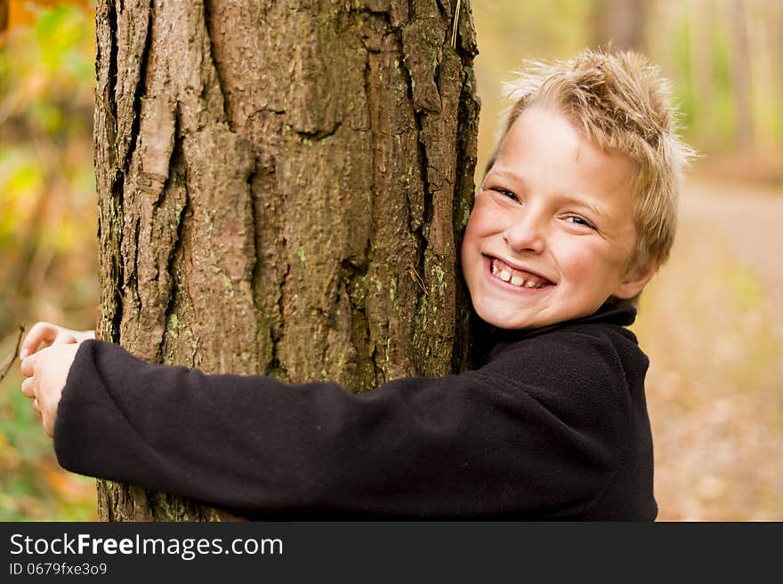 Kid in a forest hugging a tree. Kid in a forest hugging a tree