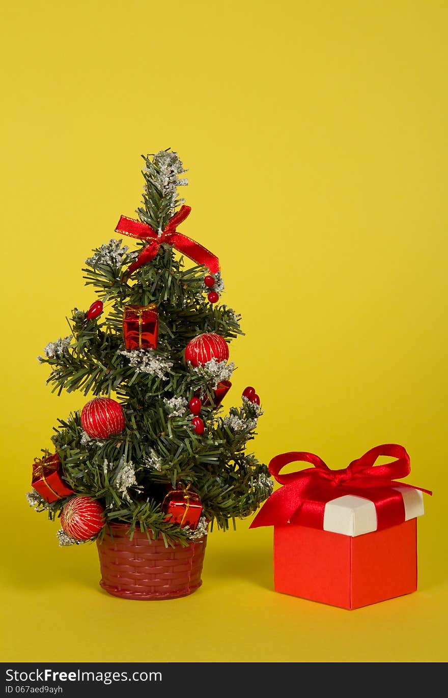 Small fir-tree in a pot with toys and gifts