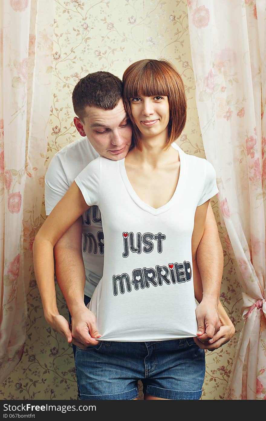 Happy newlyweds hugging T-shirts, shot in the studio