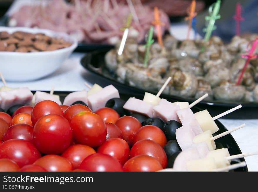 Cold snacks on the table : cherry tomatoes, canapes and meat snacks