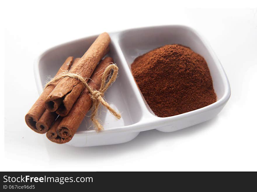 Cinnamon on white bowl. over white background. Cinnamon on white bowl. over white background