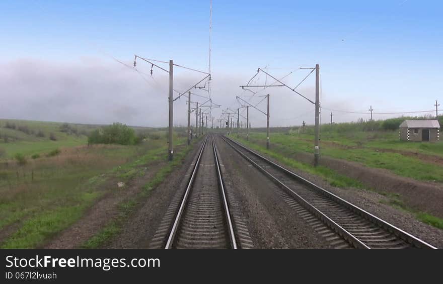 View from the last car of a train. Rails run away. Train departs from the clouds in good weather. Real sound. View from the last car of a train. Rails run away. Train departs from the clouds in good weather. Real sound