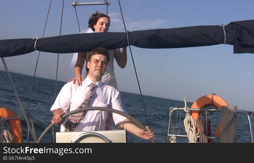 Young couple and yacht steering wheel