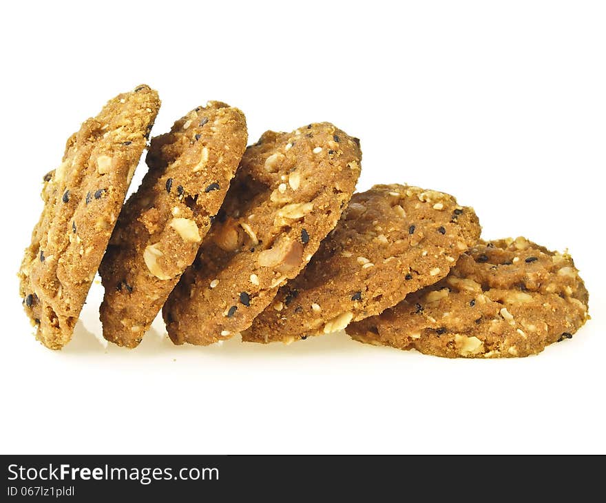 Step of pile whole grains cookies from stand to lie on white background. Step of pile whole grains cookies from stand to lie on white background