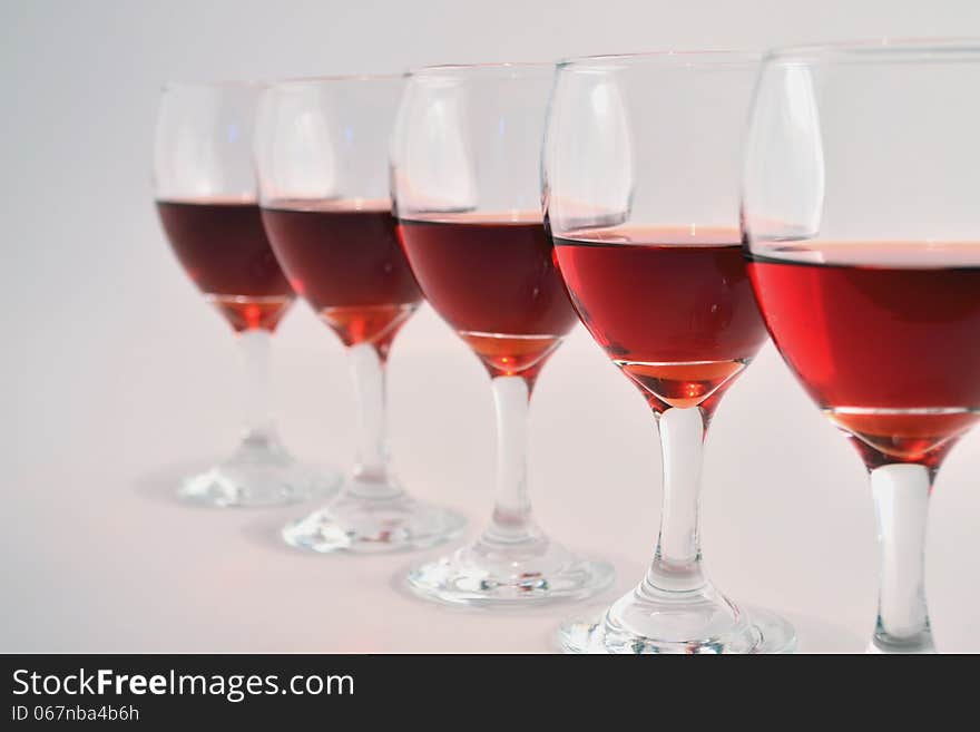 Glasses of red wine on light gray background