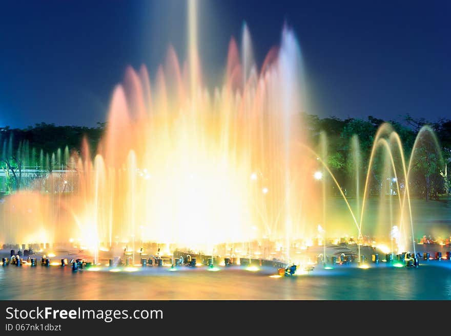 Fountain outdoors show changing color in the park. Take photo with long exposure effect.