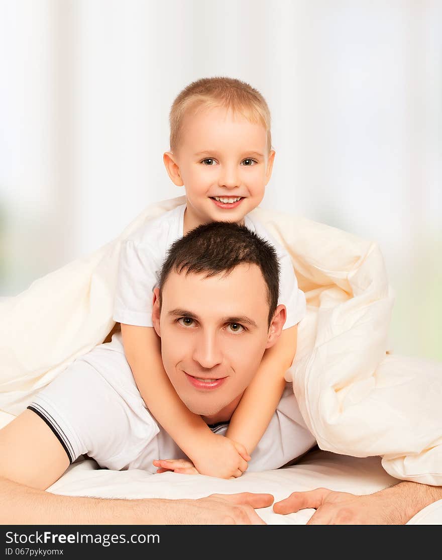 Happy Family. Dad And Son Playing In Bed