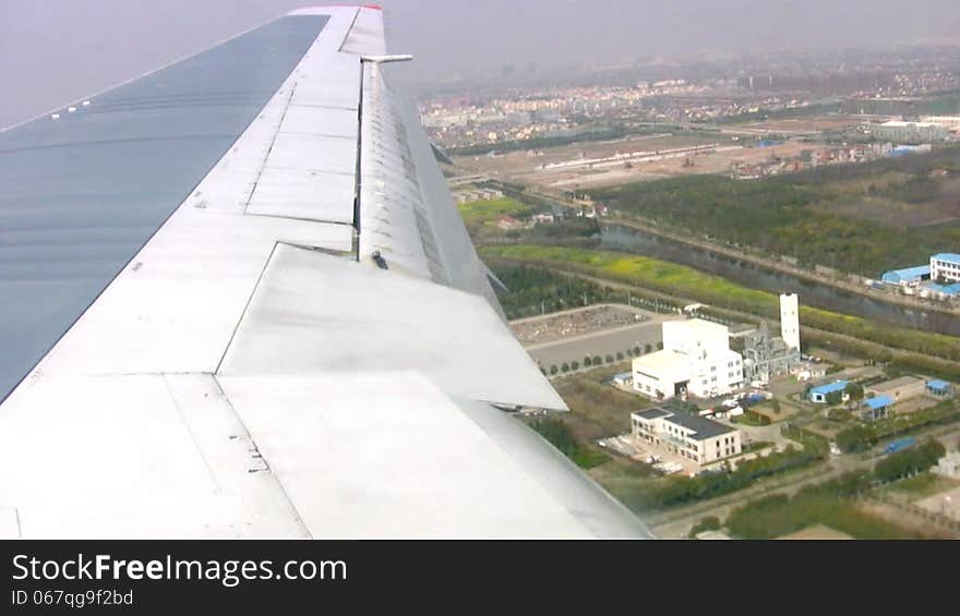 Landing of aircraft at the airport in Shanghai. A view from the porthole on the wing. Fast speed. Landing of aircraft at the airport in Shanghai. A view from the porthole on the wing. Fast speed