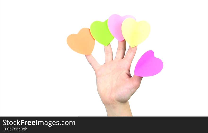 On the fingers of the women's hands are glued five colorful paper labels in the form of hearts. Hand waving on a white background. On the fingers of the women's hands are glued five colorful paper labels in the form of hearts. Hand waving on a white background