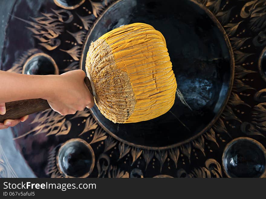 Hand hit big gong in temple